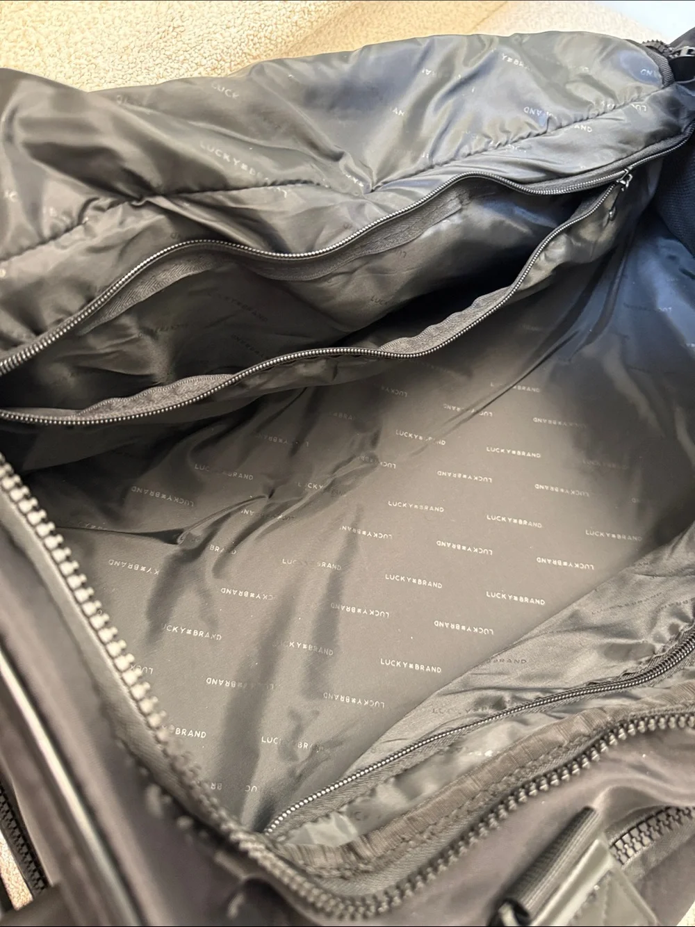 Lucky Brand Black Men's rolling Duffel w/ telescopic handle. Multiple zip areas.